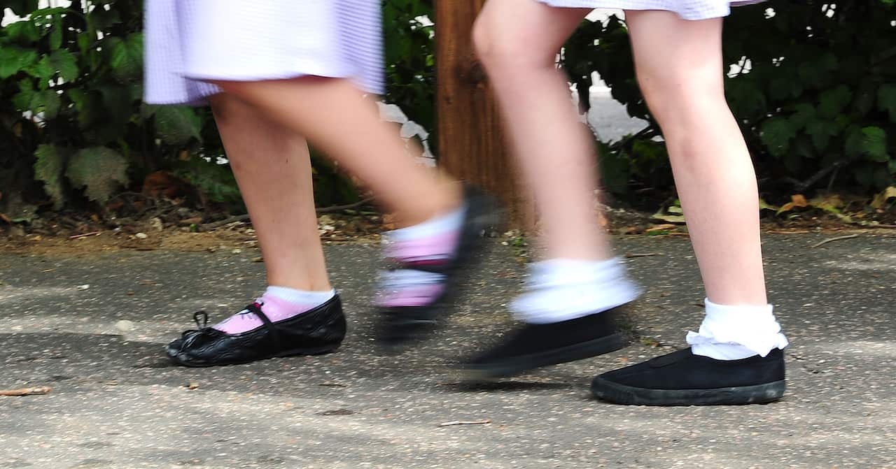 The legs of two girls walking