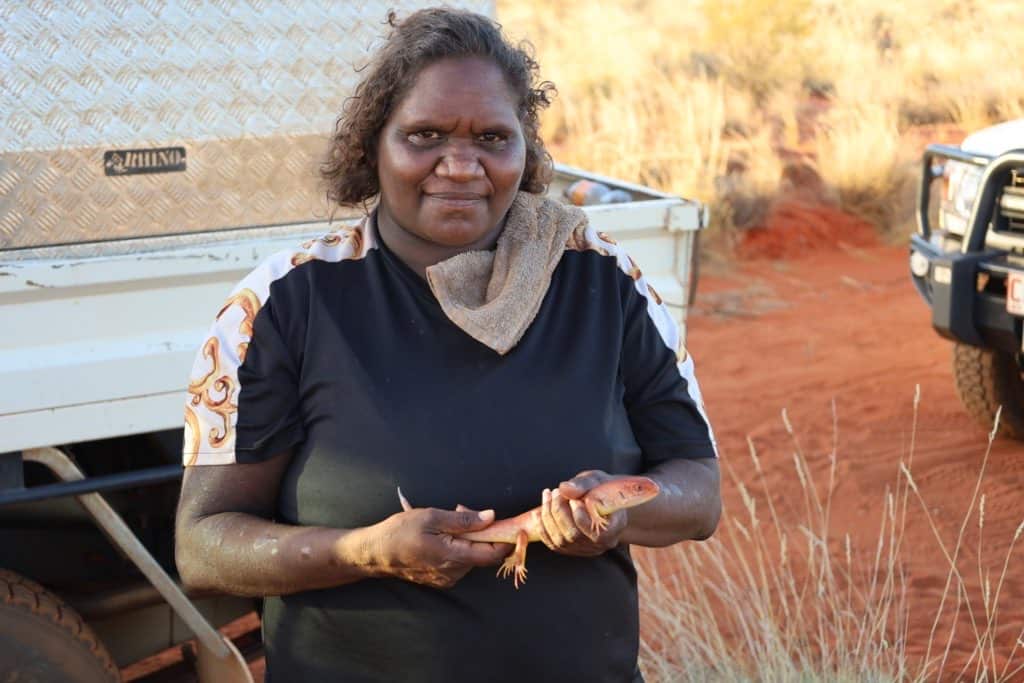 A woman holding a lizard outside