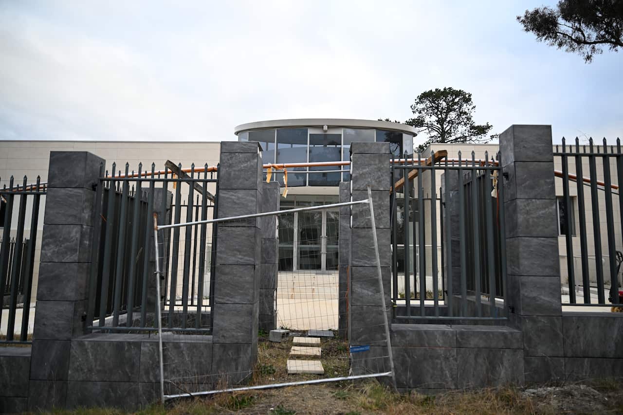A partially built building behind a fence.