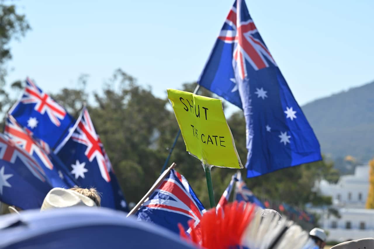 Australian flags alongside a sign that says 'SHUT THE GATE'.