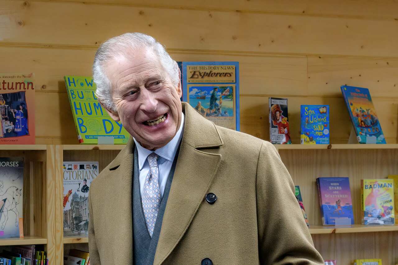 King Charles smiling in a tan coat.