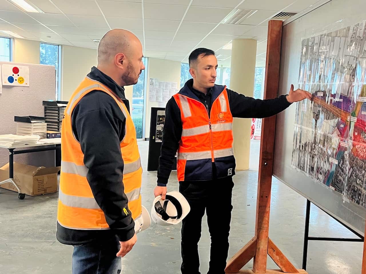 Abdulwahed Salloum (left) and Tariq Zia look at photographs on a whiteboard