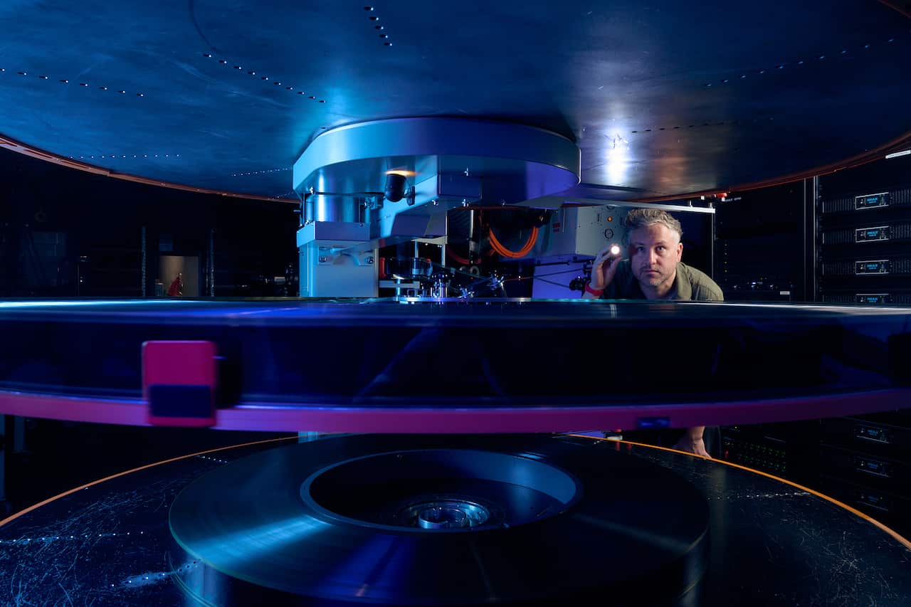 A man looking at the inside of a film reel.