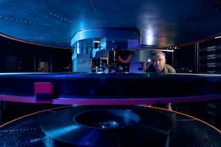 A man looking at the inside of a film reel.