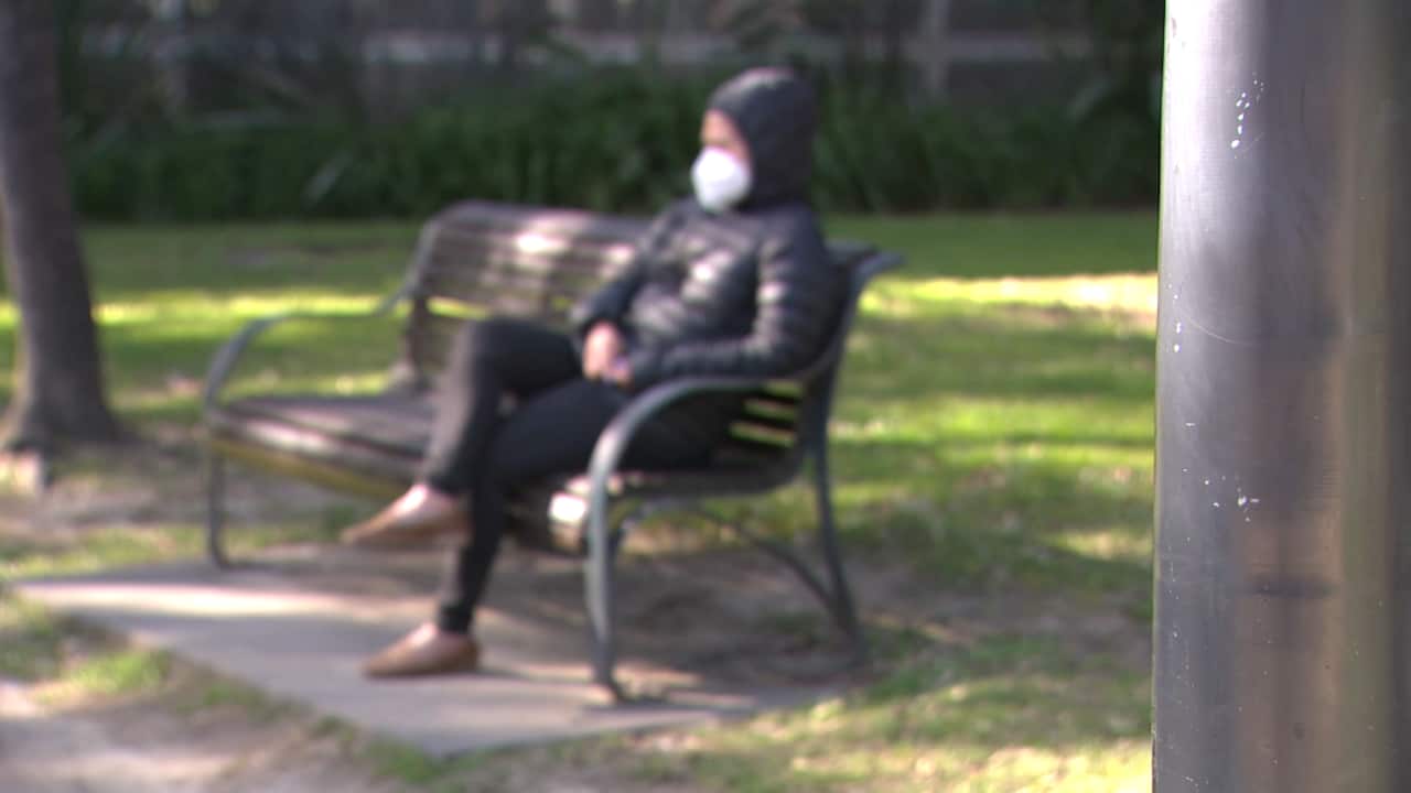 A woman sitting on a park bench.