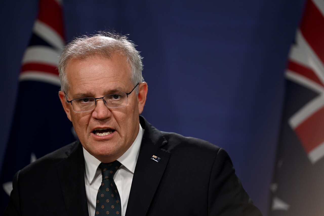 A man wearing a suit and tie speaking.