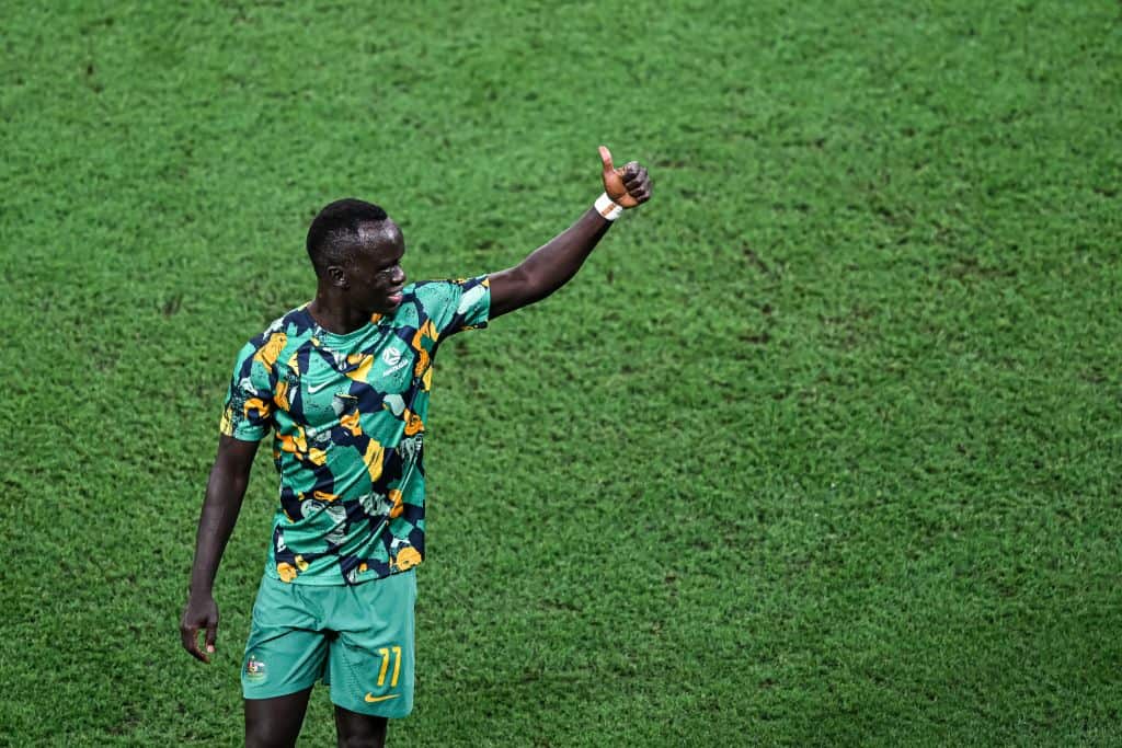 A football player gestures a thumbs up during a match. 