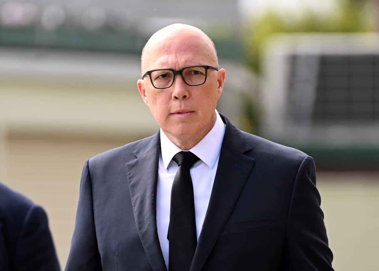 A bald man in glasses and suit.