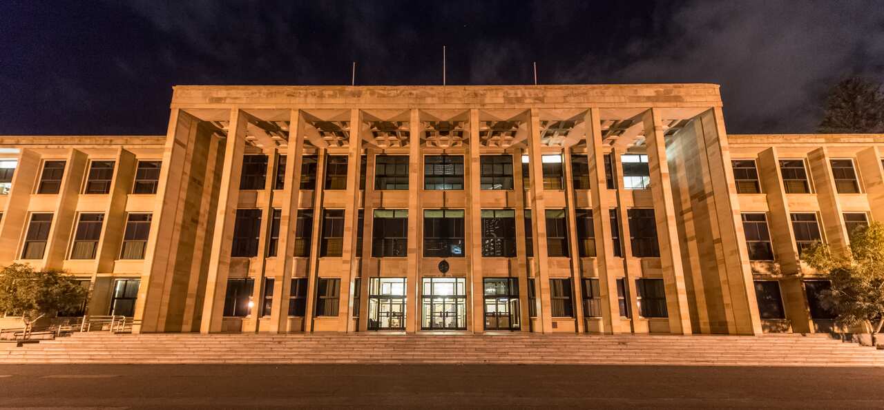 A three storey building lit up at night.