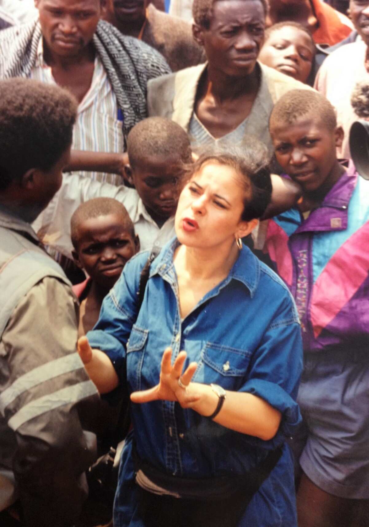 A wide-shot from above, of Helen at talking to people in a Goma refugee camp.