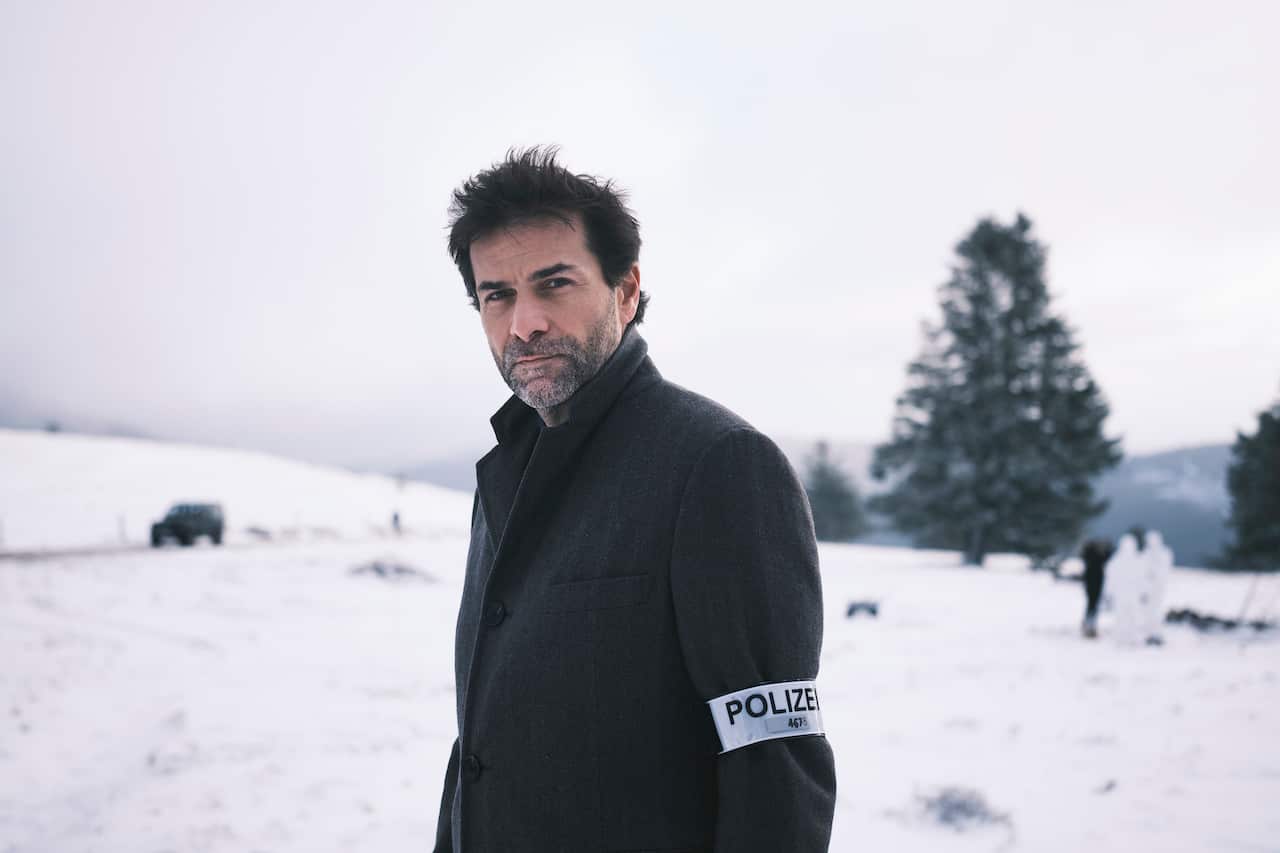 Actor Grégory Fitoussi stands in the snow looking directly at the camera in his show Forest of the Missing