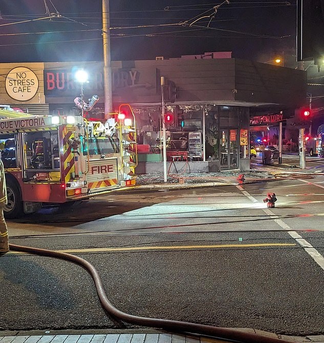 A firetruck in front of a burnt out building