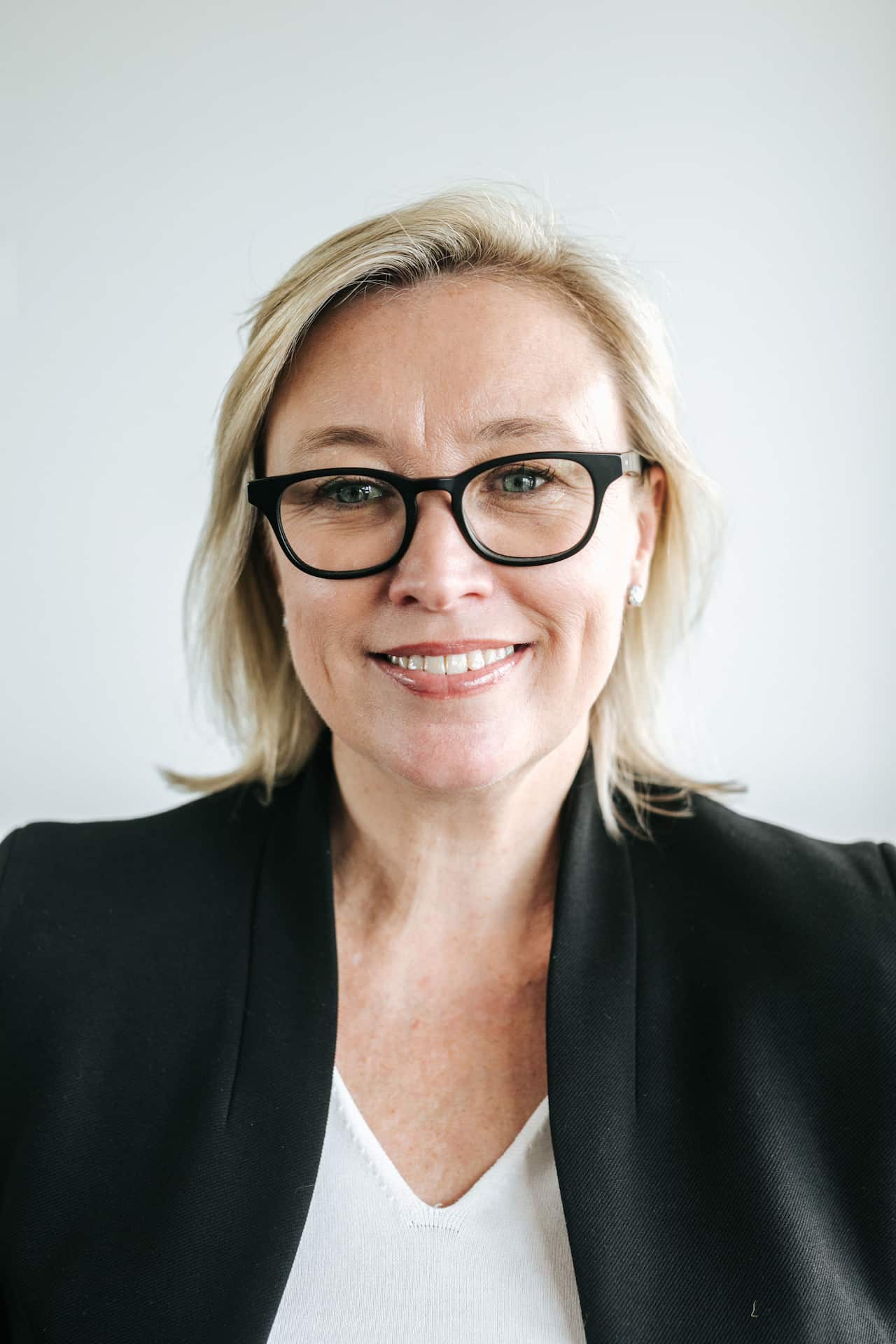 A woman wearing glasses and a blazer.