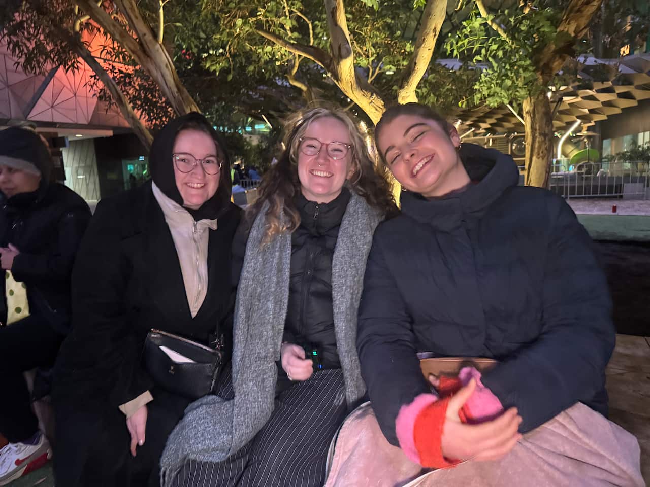 Three young women in puffer jackets and scarves