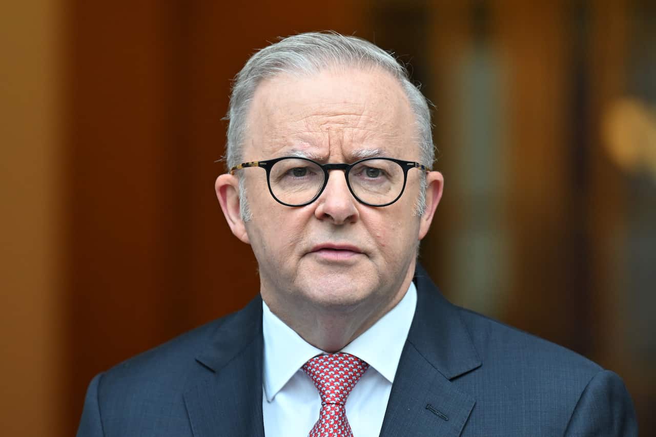 Anthony Albanese, wearing a blue blazer, white shirt and red tie.