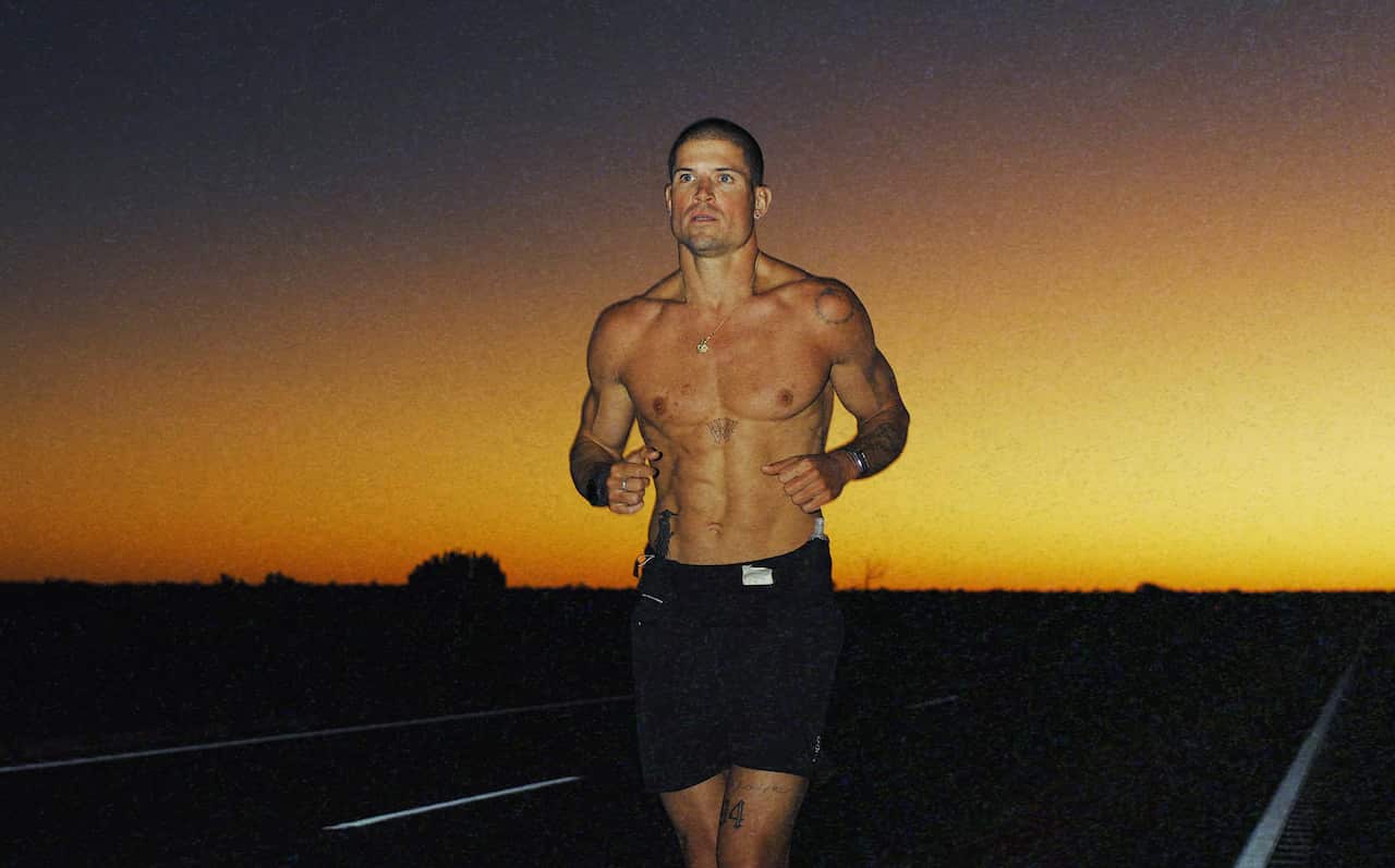 A man running on a road as the sun sets