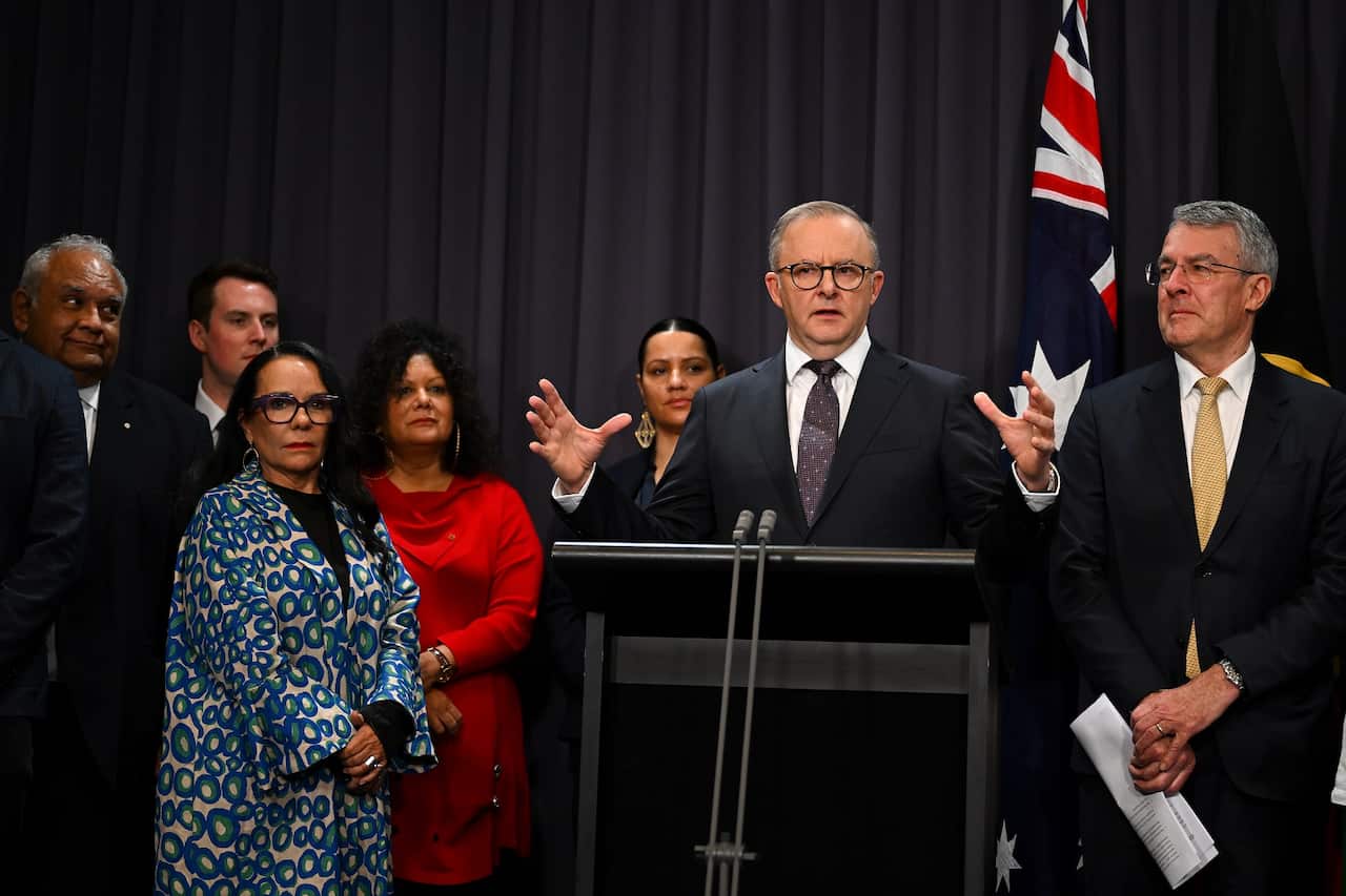 Man speaks at a lectern in front of a group of people.