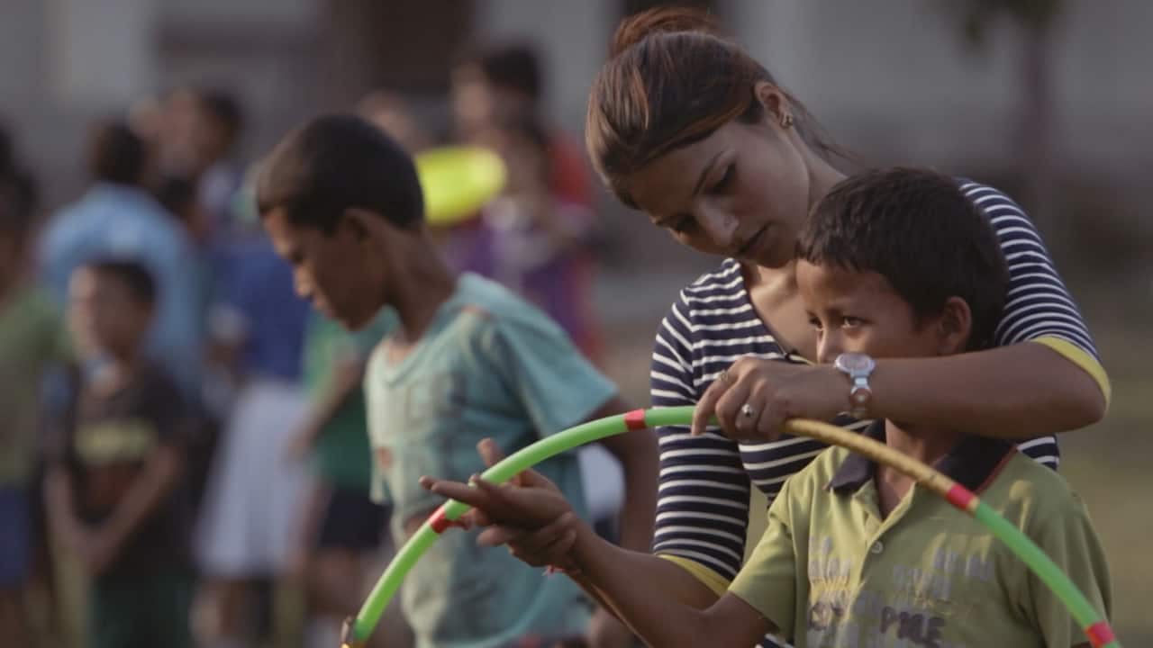 A woman holding a hula hoop with a young child.