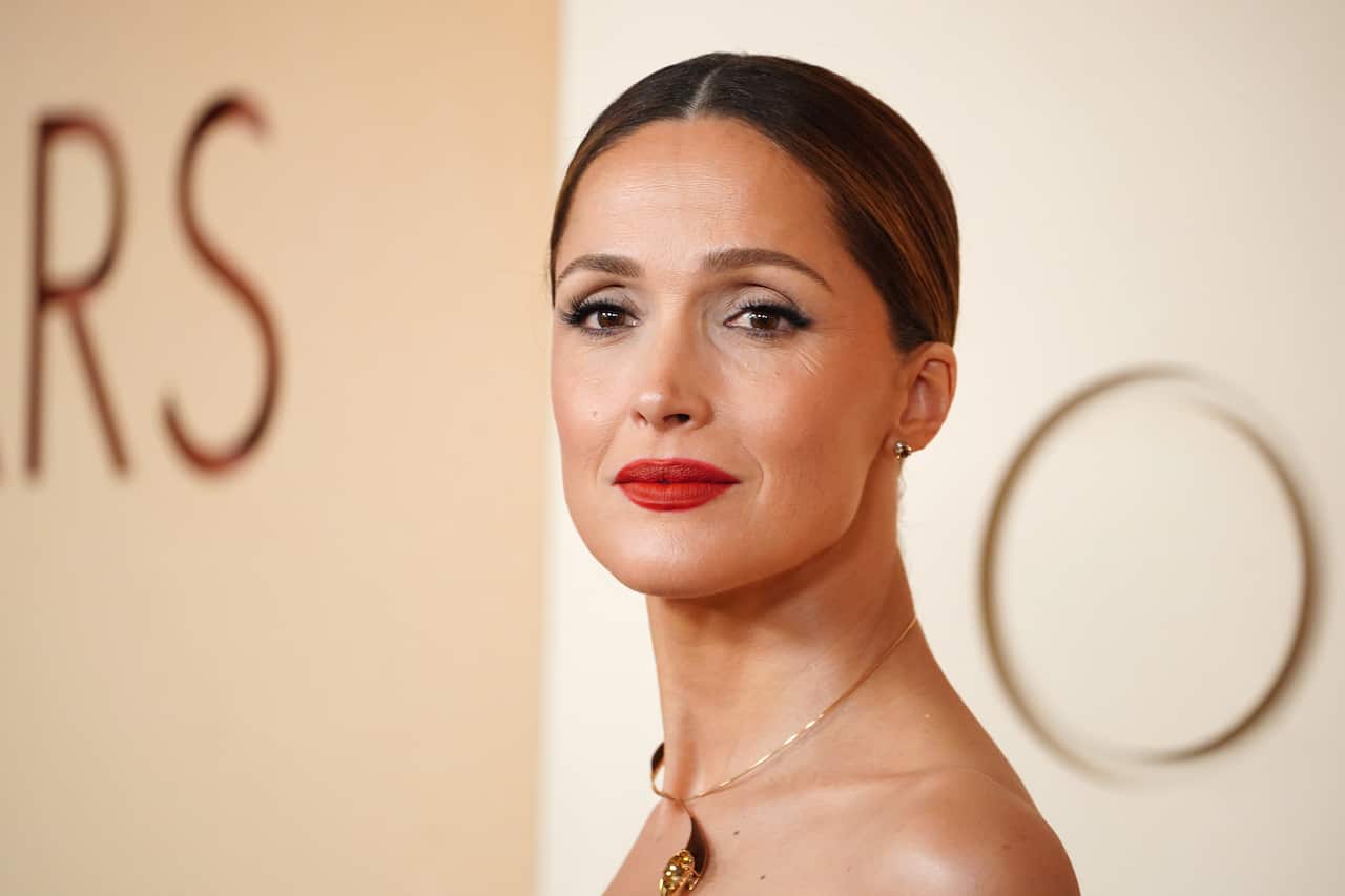 A woman in front of a gold wall.