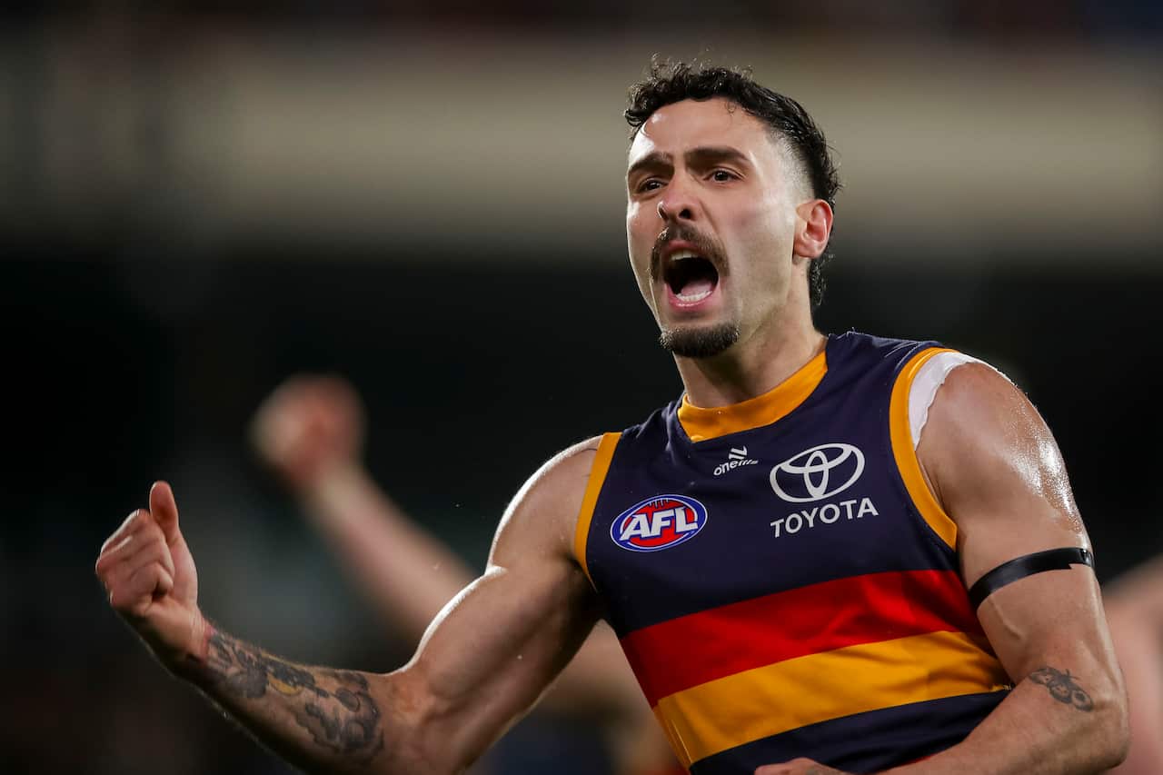An AFL player in a guernsey with blue, yellow and red bands 