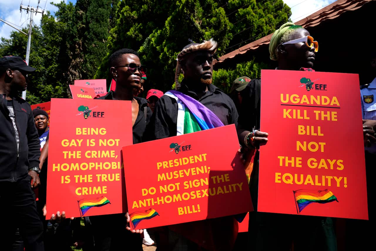 Ugandans holding signs stating homophobia is a crime, not homosexuality