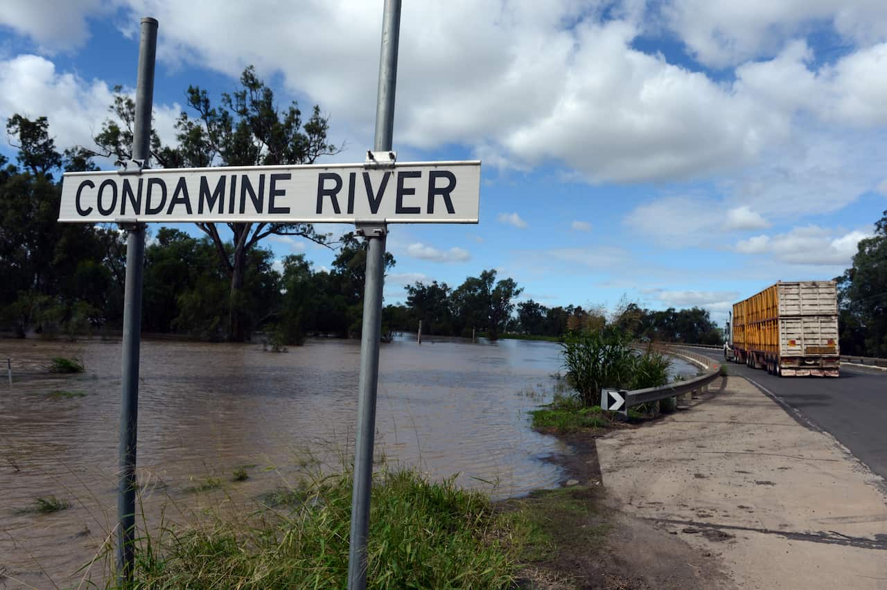An image of a full Condamine River, with a sign saying Condamine River near a road.