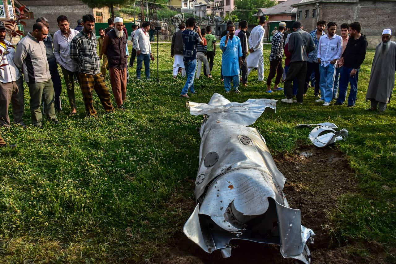 People gather around the debris of an unidentified missile.