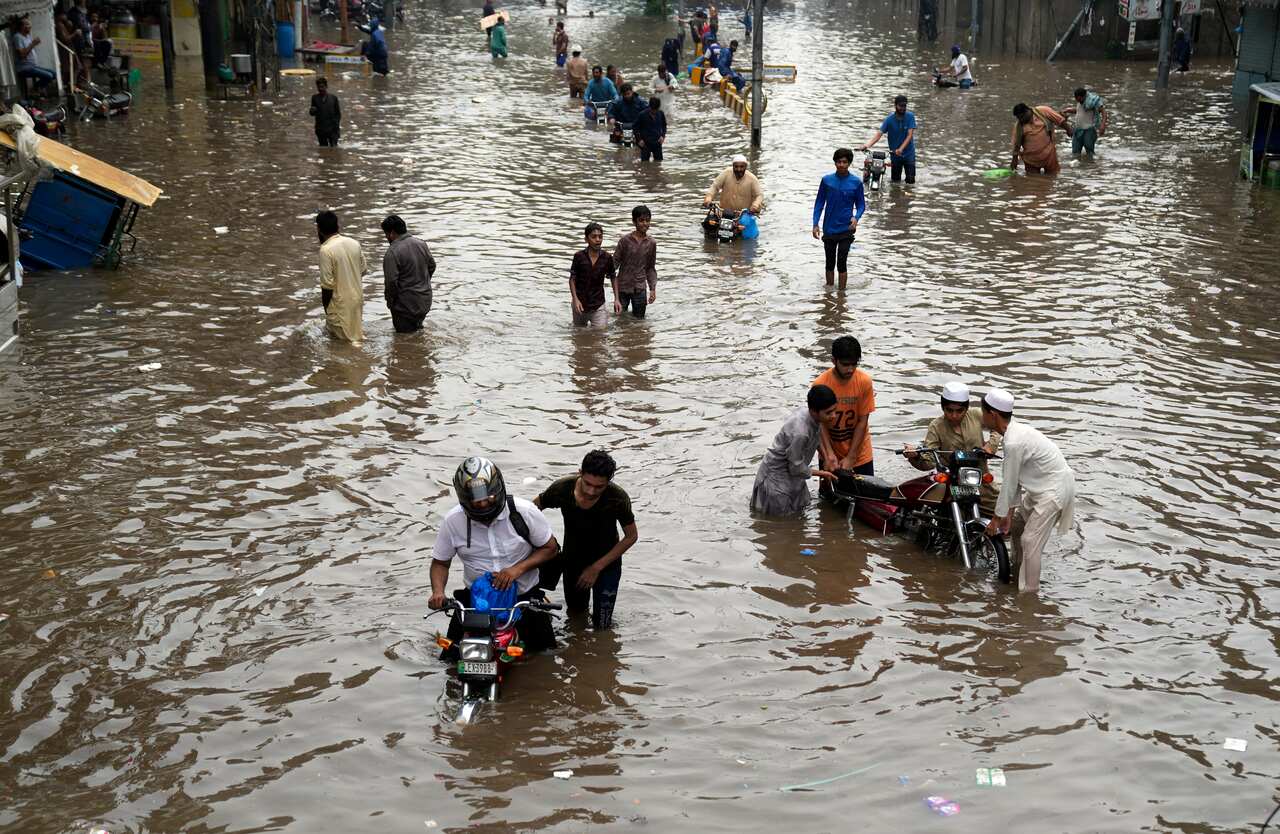 People walking through floodwater.