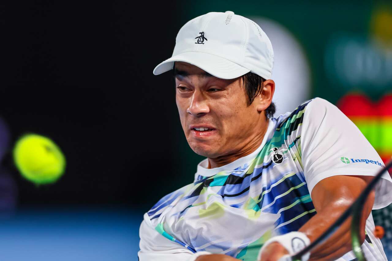 A man about to hit a tennis ball.