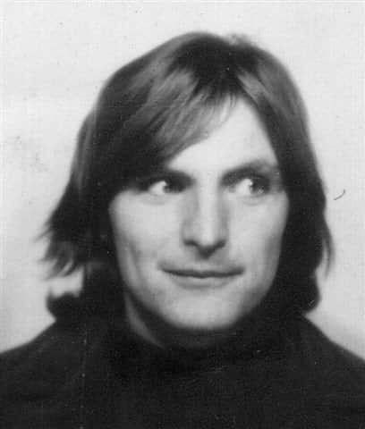 A black and white photo of a man with long hair looking to the right