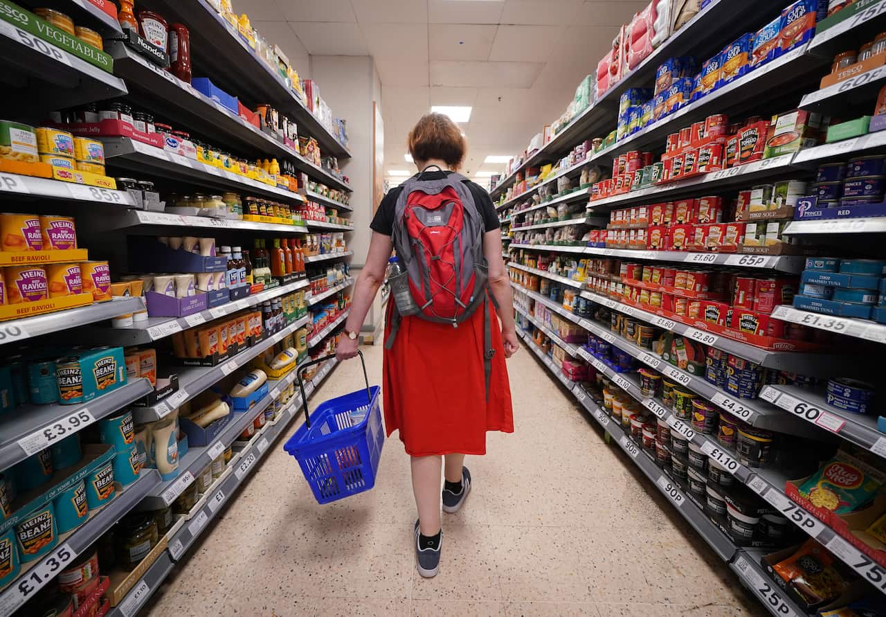 A woman carrying a shopping basket at a grocery store