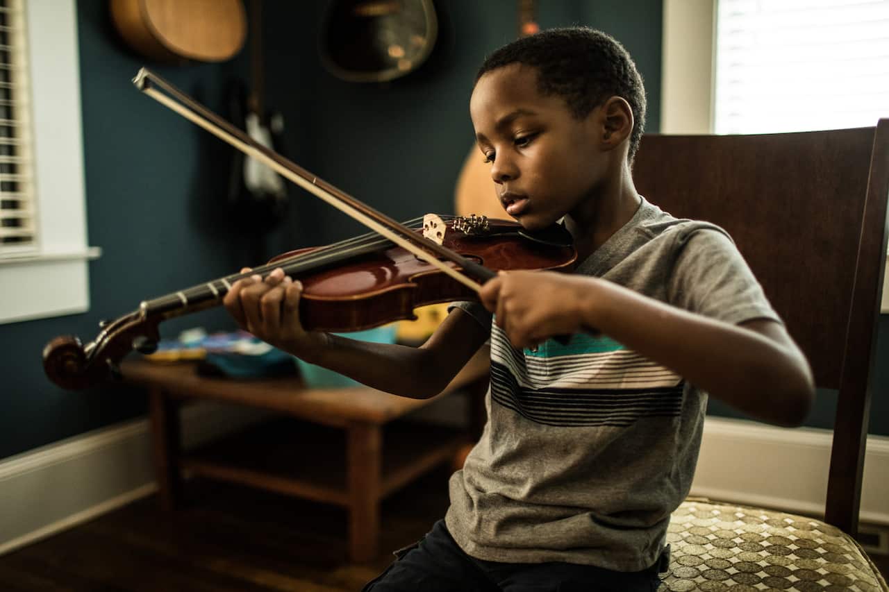 Young boy (6 yrs) practicing violin