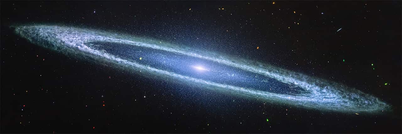 A broad-rimmed spiral galaxy seen through a telescope.