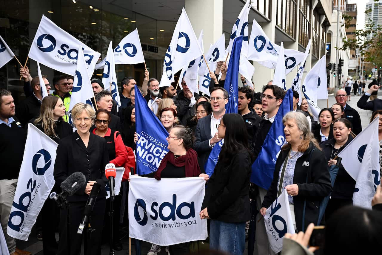 A group of people gathered at a rally, holding SDA flags.
