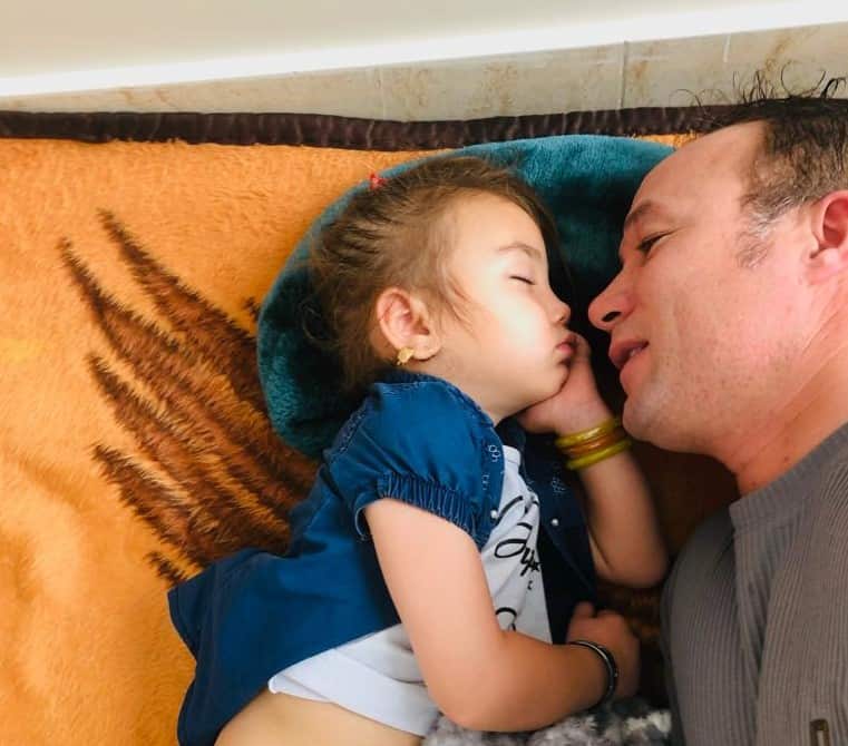 Hussaini lying next to his daughter sleeping.