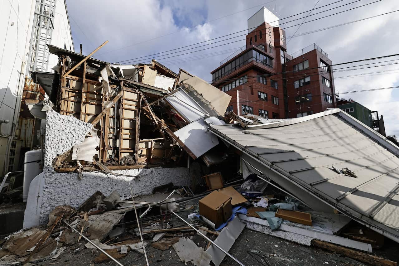 A house that has collapsed in an urban area. Rubble litters the ground.