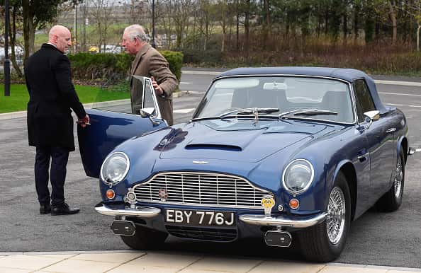 Prince Charles getting out of his Aston Martin car