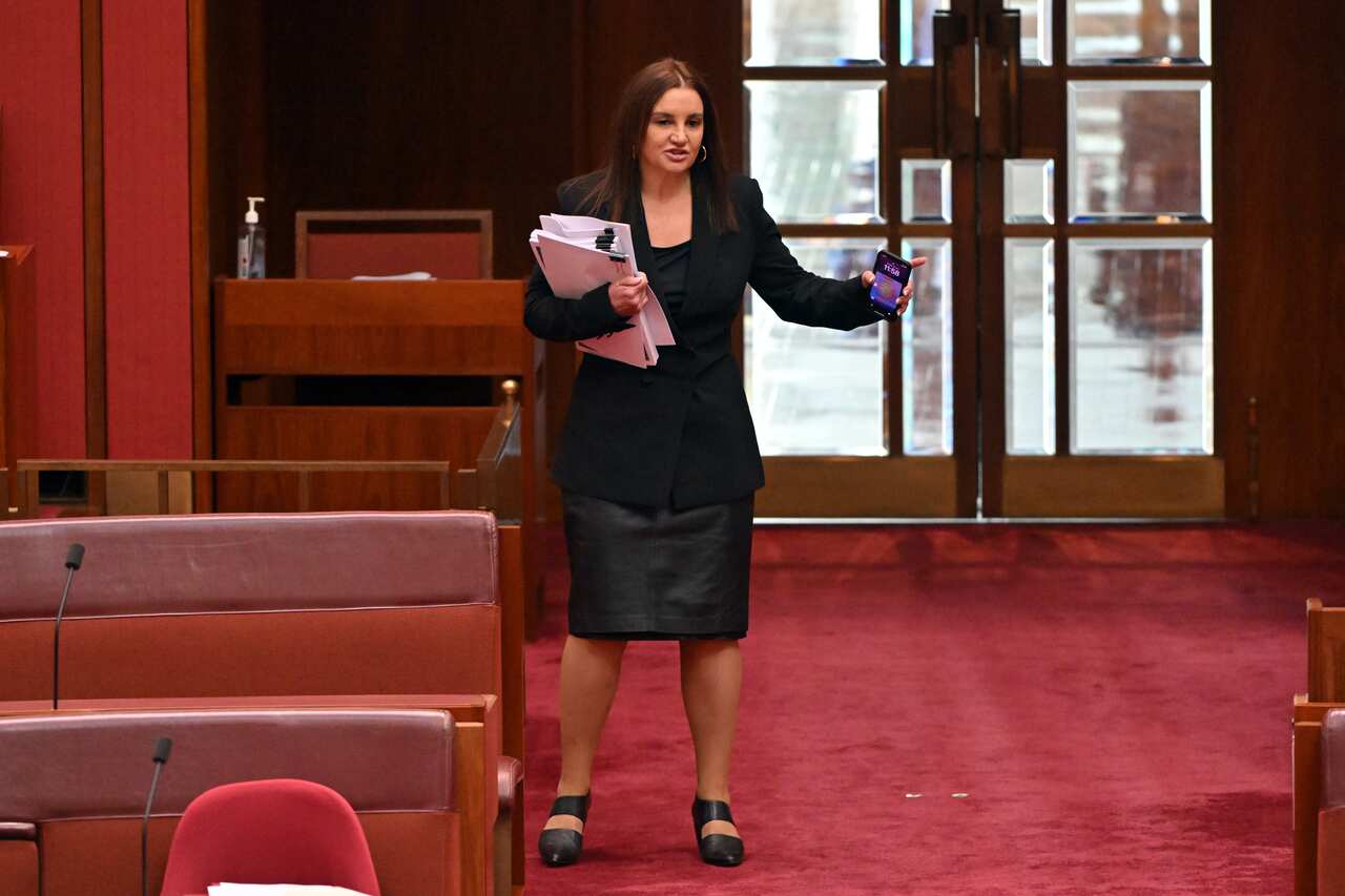 Woman in black stands in the Senate.