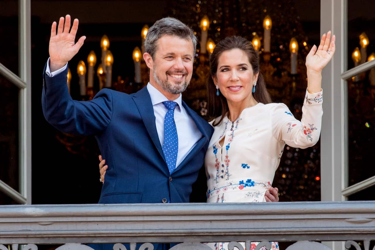 Prince Frederik and Princess Mary wave from a balcony