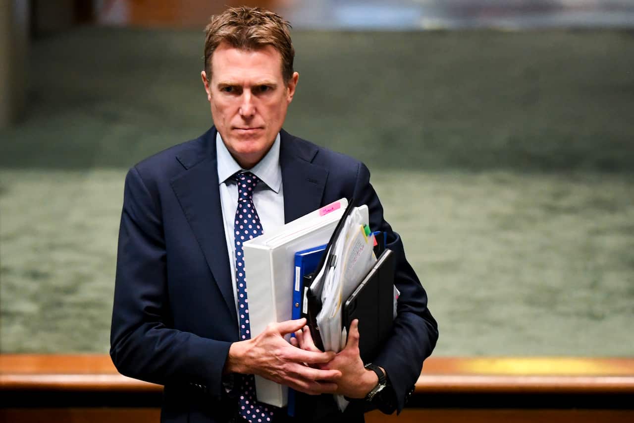 A man walking while holding folders.