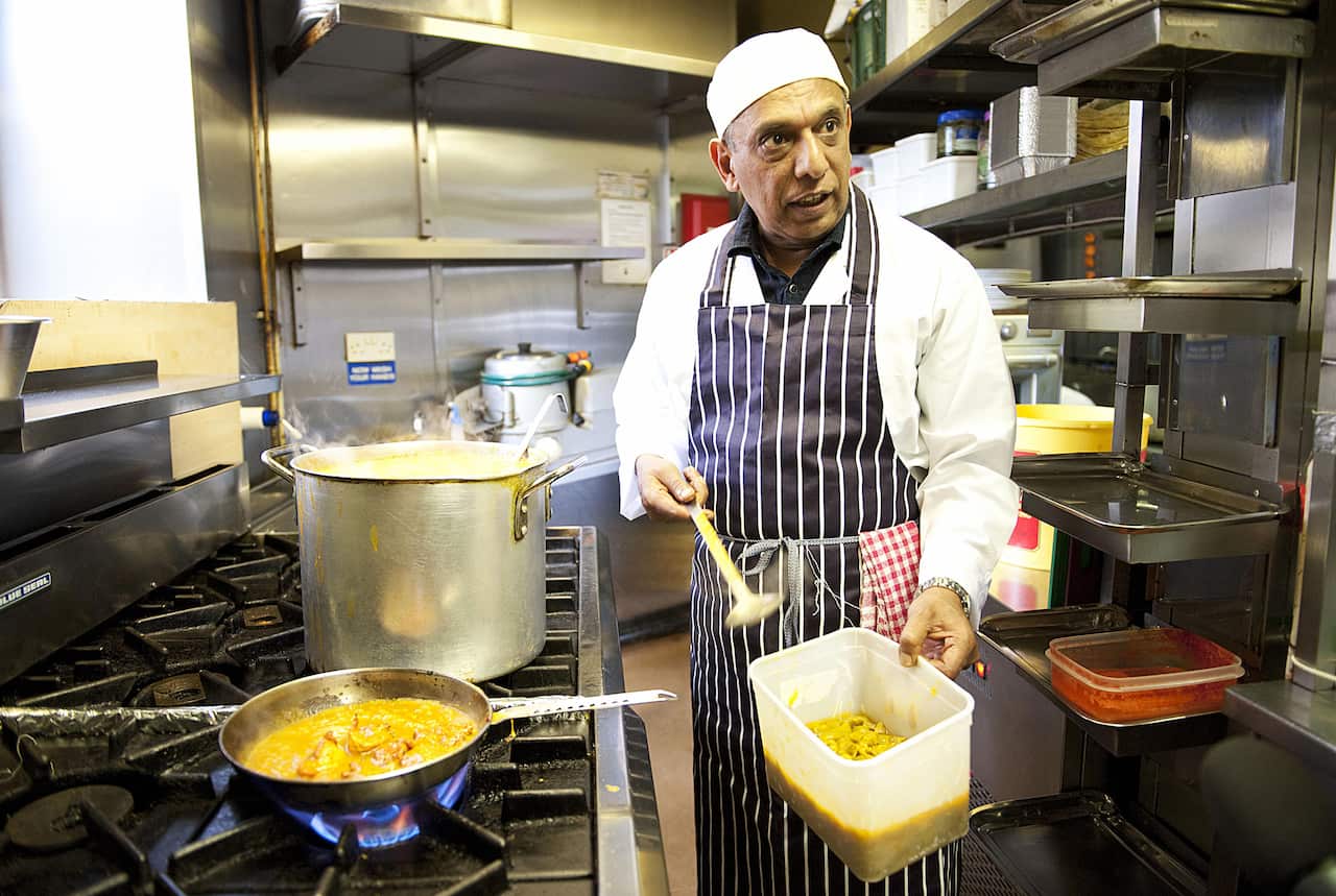 A chef at the Shish Mahal restaurant prepares the dish in the kitchen.