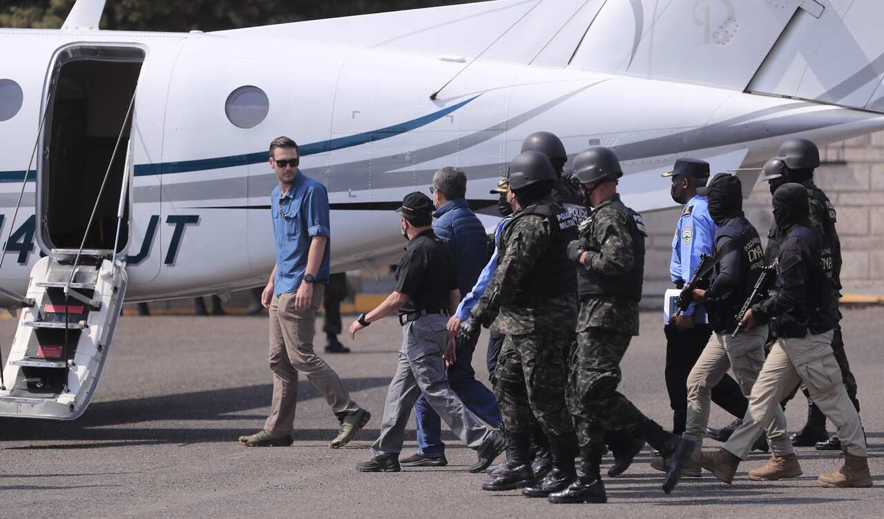 Former Honduran President Juan Orlando Hernandez is escorted by police as he's about to board a plane to head to the US.