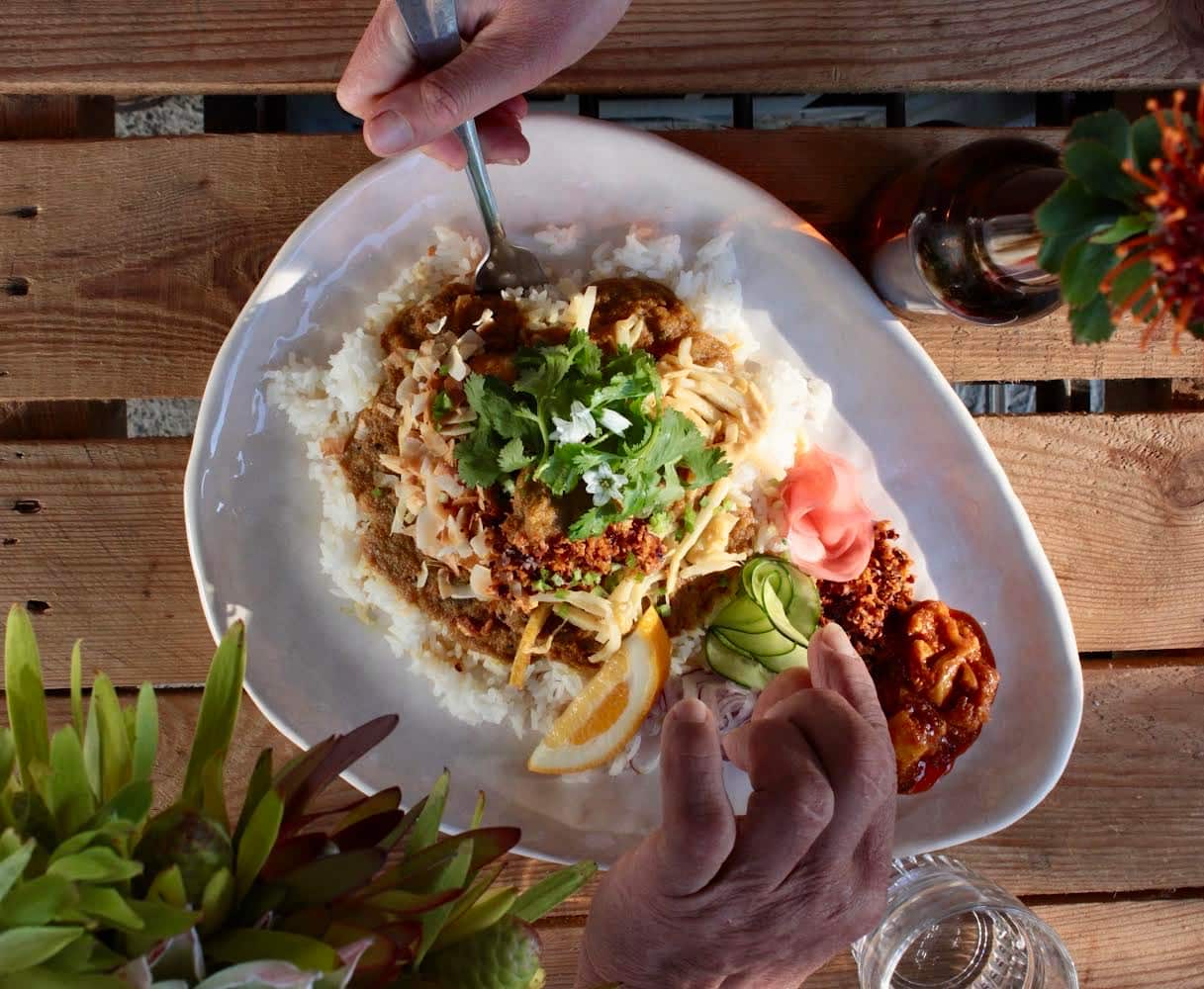 Rice in a dish with curry on a wooden table