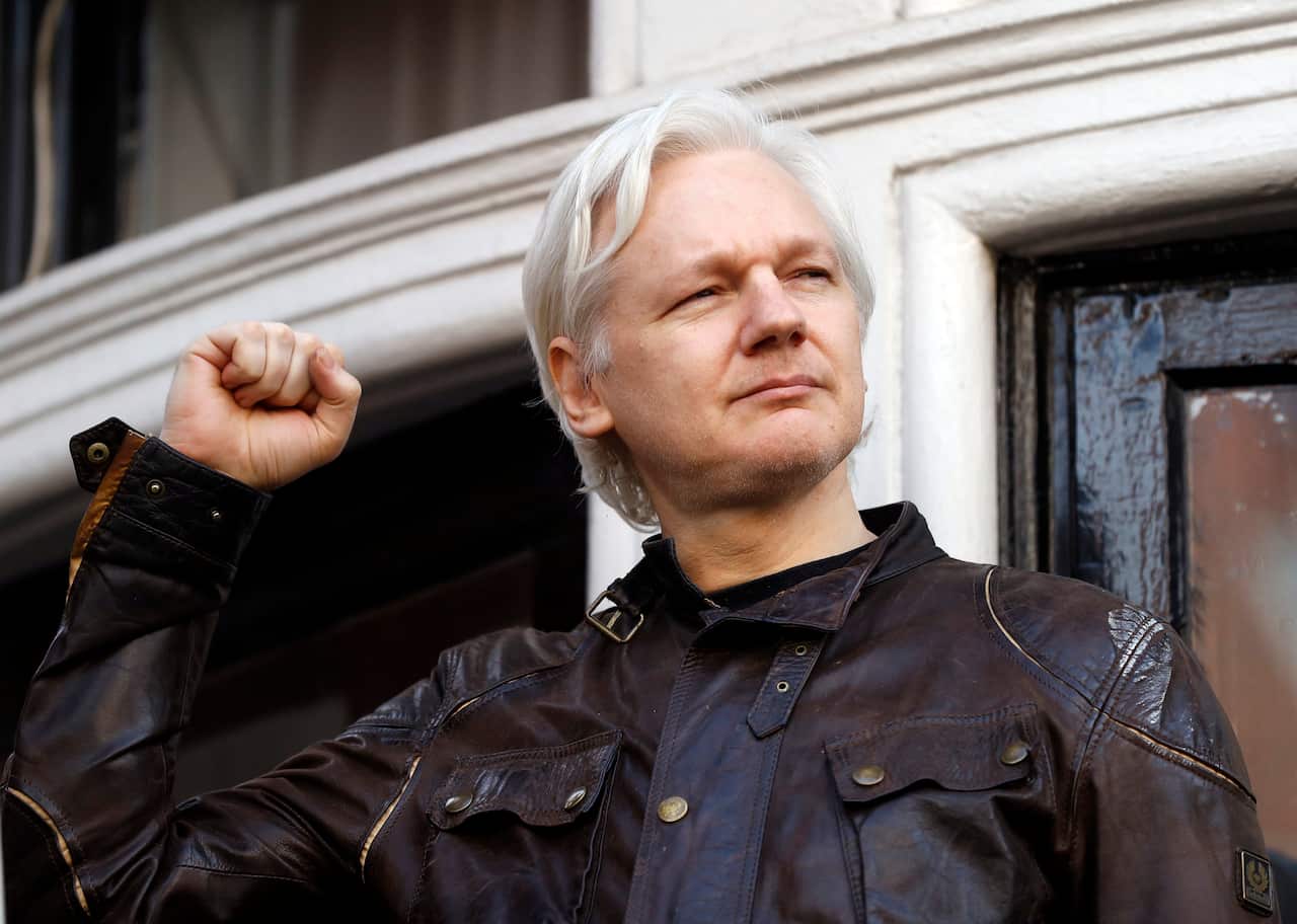 Julian Assange greets supporters outside the Ecuadorian embassy in London