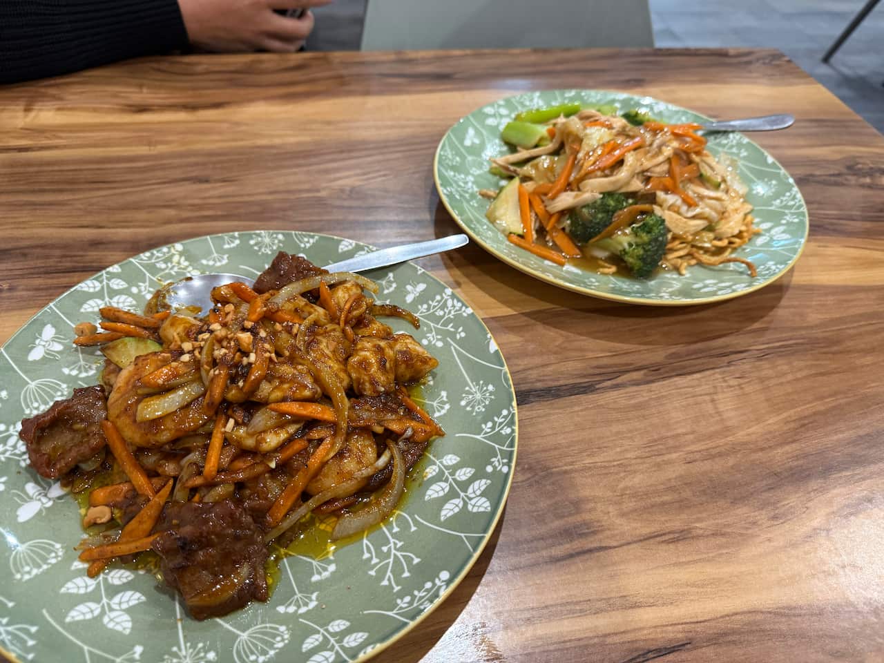 Two stir-fry dishes sitting on a table.