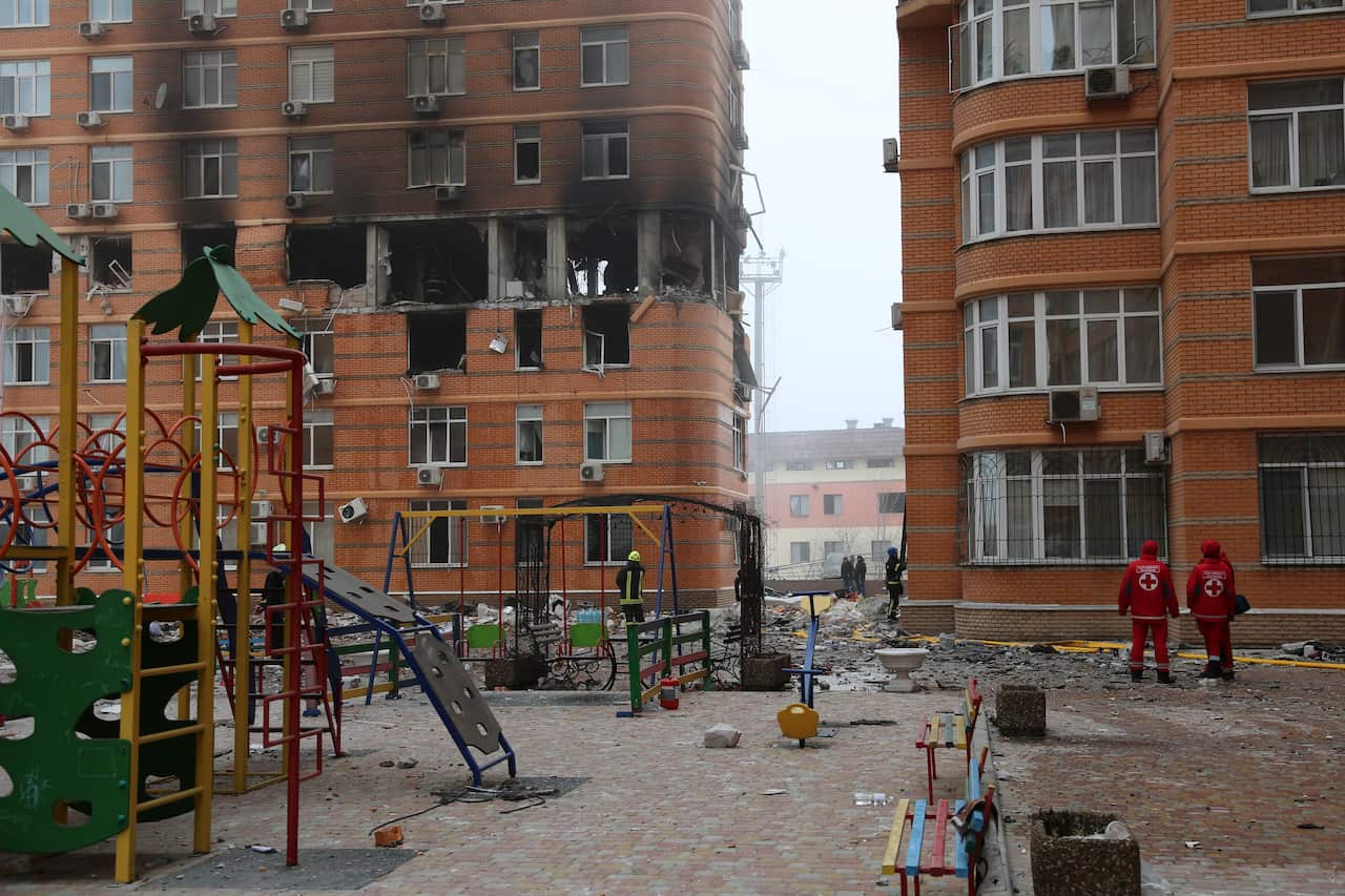 A playground in front of a buildings with several burned out rooms