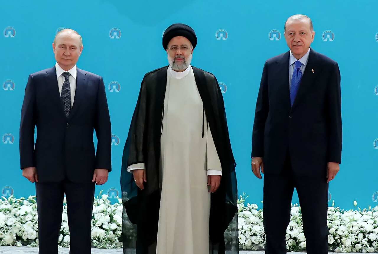 Three men wearing suits standing.