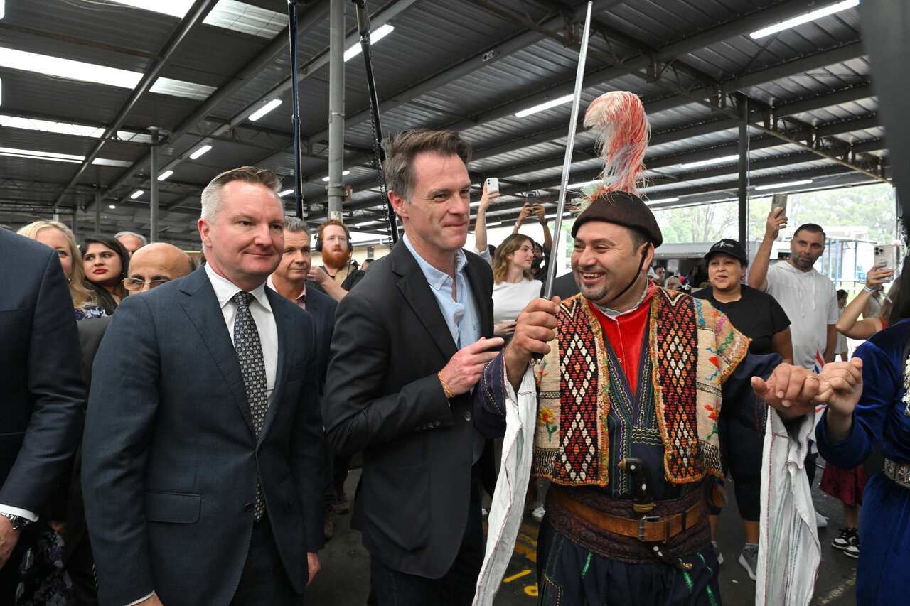 Chris Bowen and Chris Minns standing surrounded by people at a cultural event.