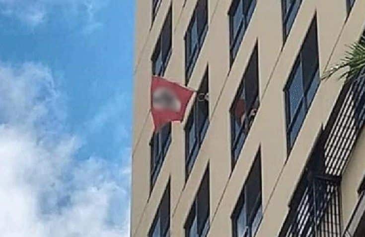 A Nazi flag flown outside a building with swastika blurred.