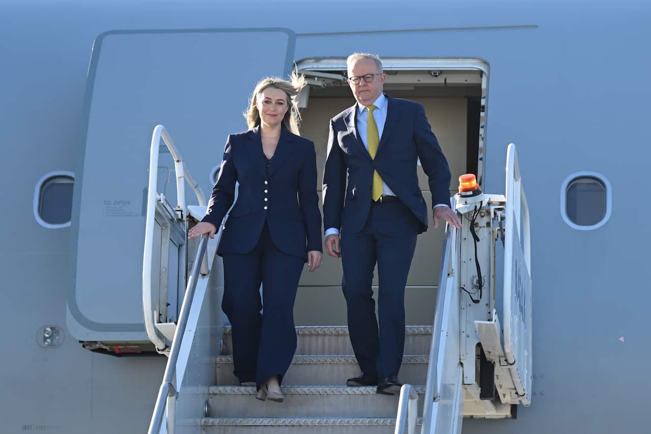 Anthony Albanese is exiting a plane with partner Jodie Haydon.